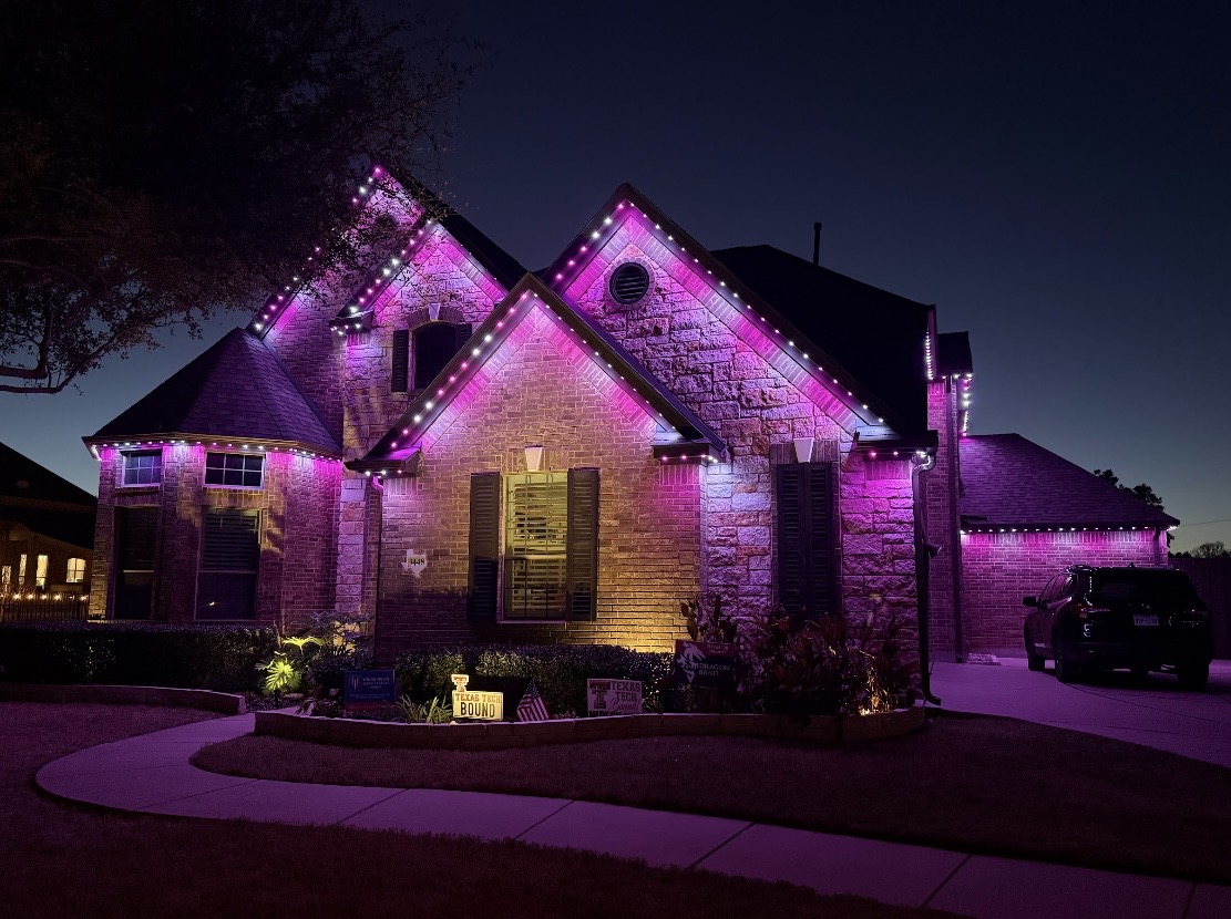Pink + Purple permanent roofline lighting on a home